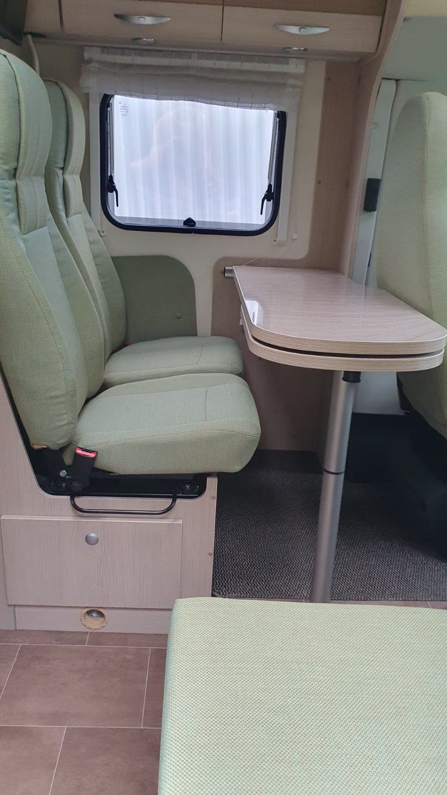 Grüne Wohnmobil-Sitze mit Tisch und Fenster