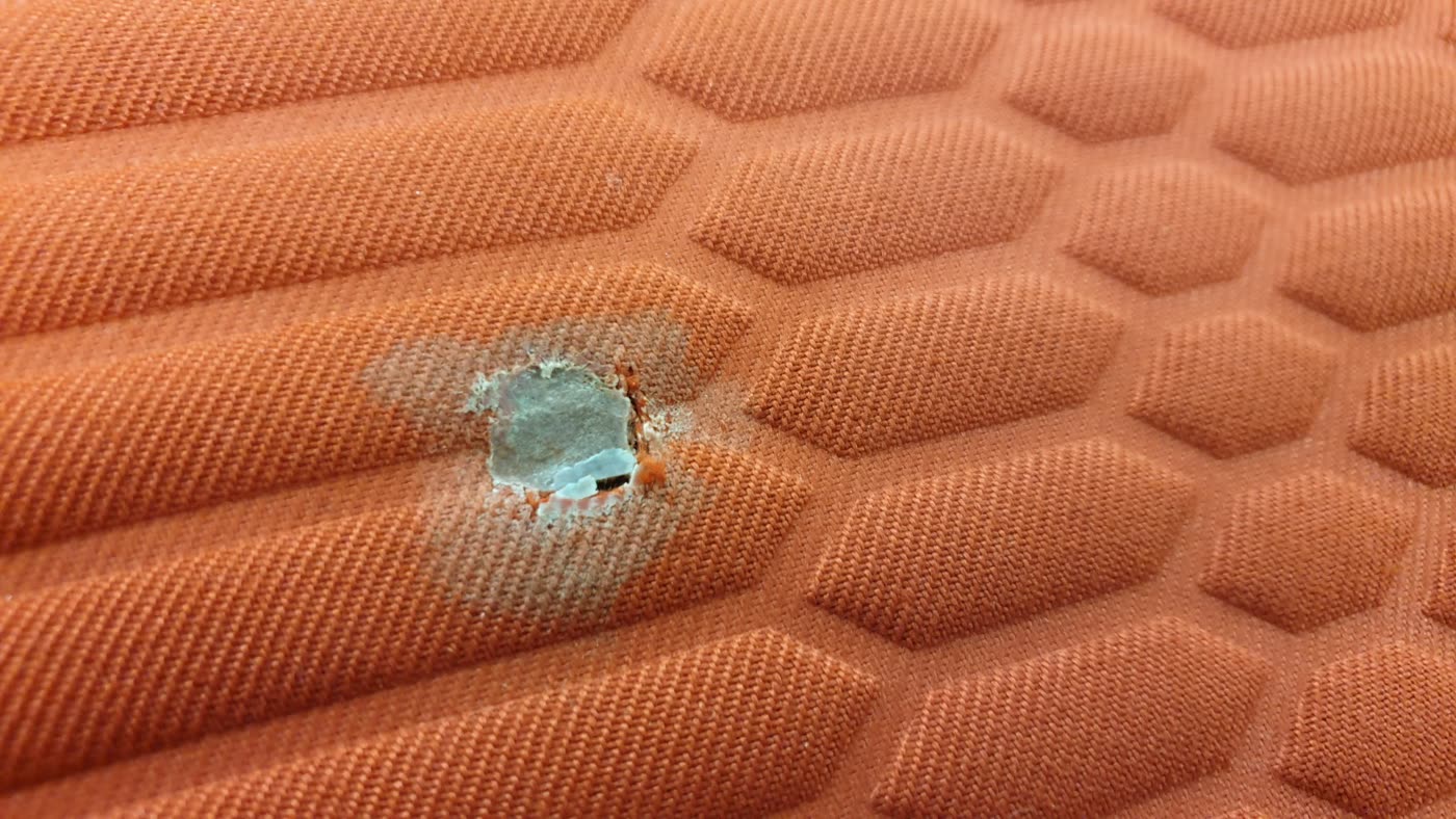 Orangenes Bootspolster mit Loch beschädigt