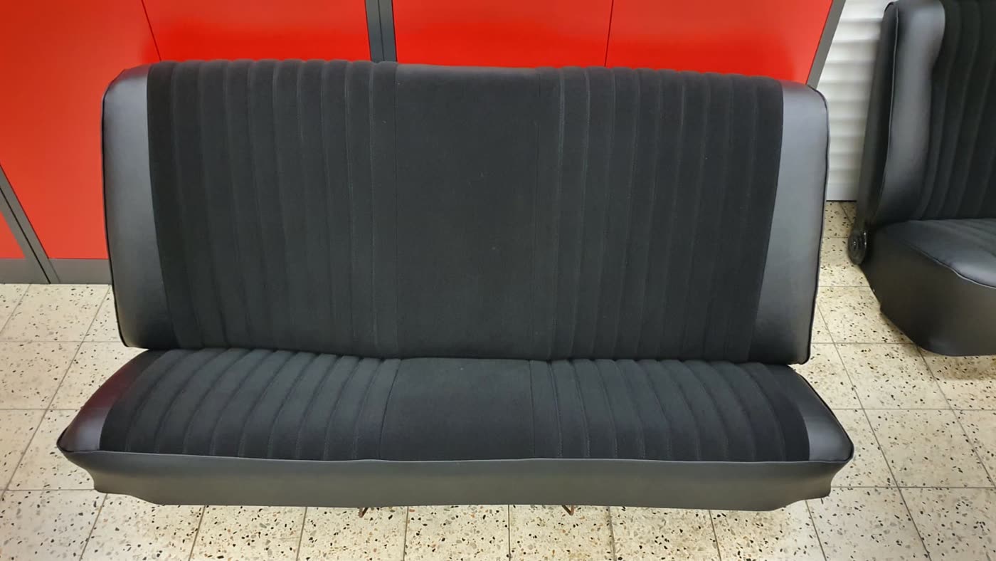 Schwarze Rücksitzbank vor roter Wand