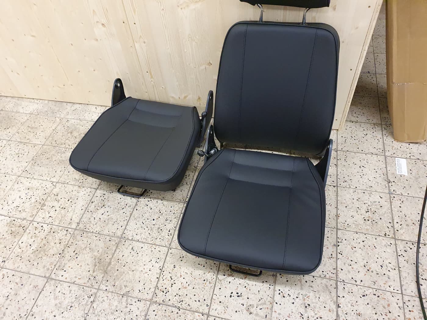 Schwarzer Sitz mit Armlehnen und separater Sitzfläche