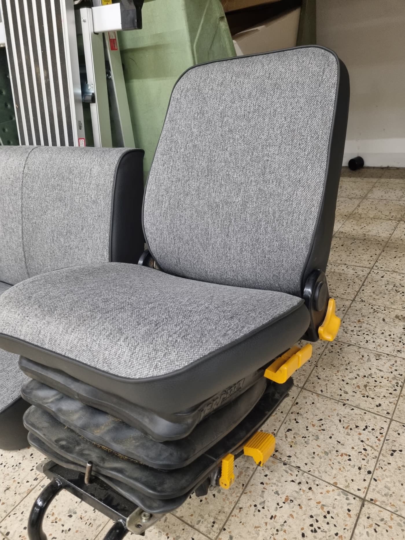 Grauer Einzelsitz mit gelben Schnellverschlüssen, Van