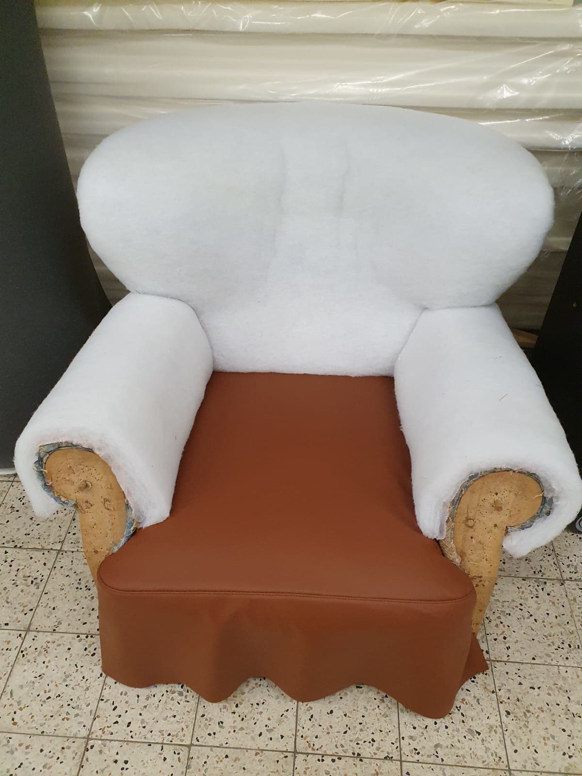 Sessel im Rohzustand, weißes Vlies, brauner Sitzkissenbezug