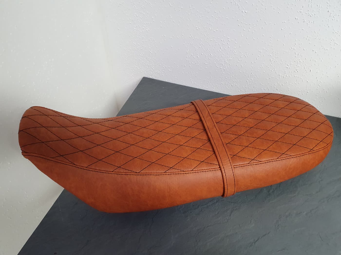 Cognac-braune Rautensitzbank mit Gurt, andere Perspektive