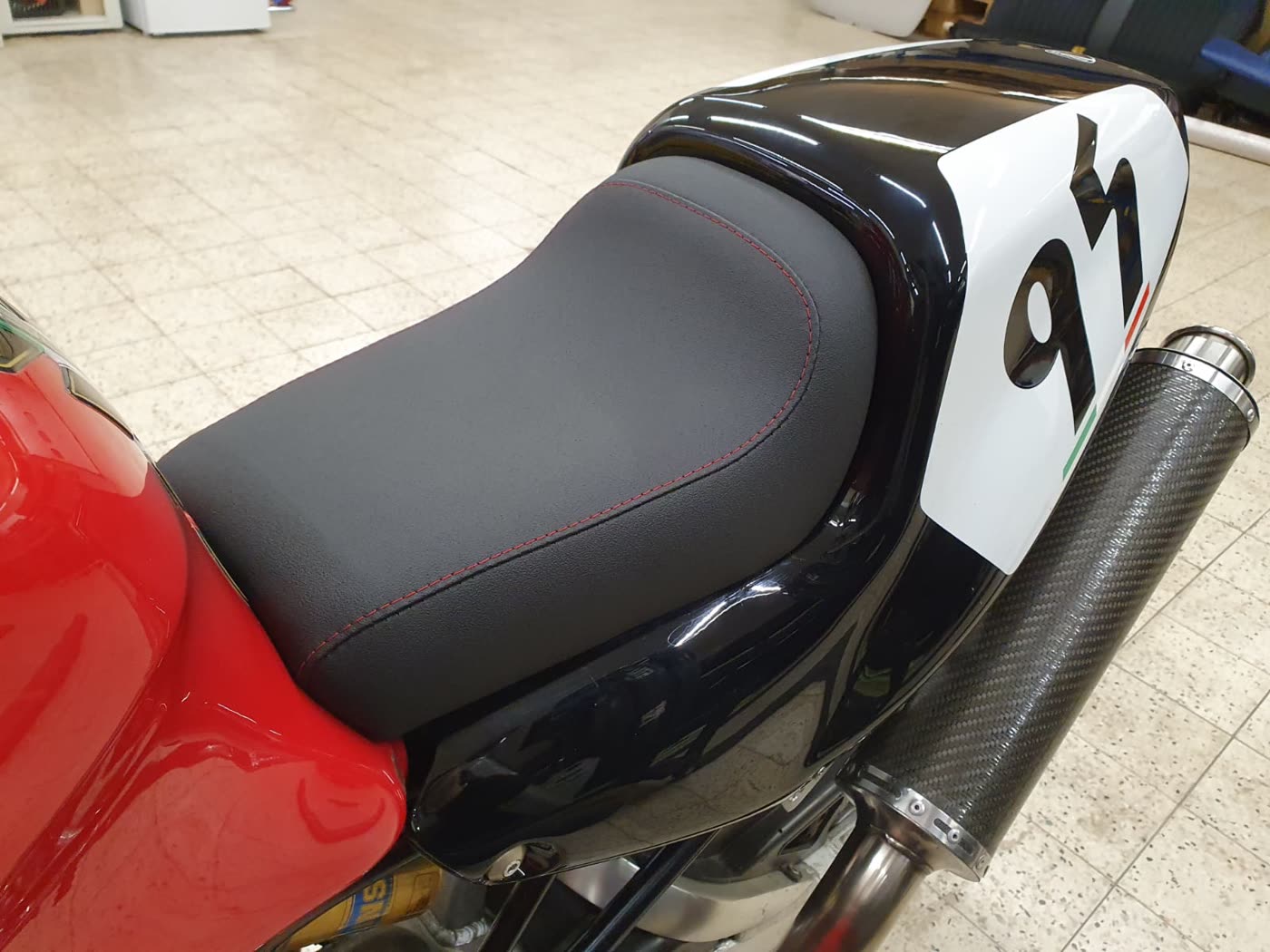 Graue Sitzbank mit roter Naht auf Ducati-Racer