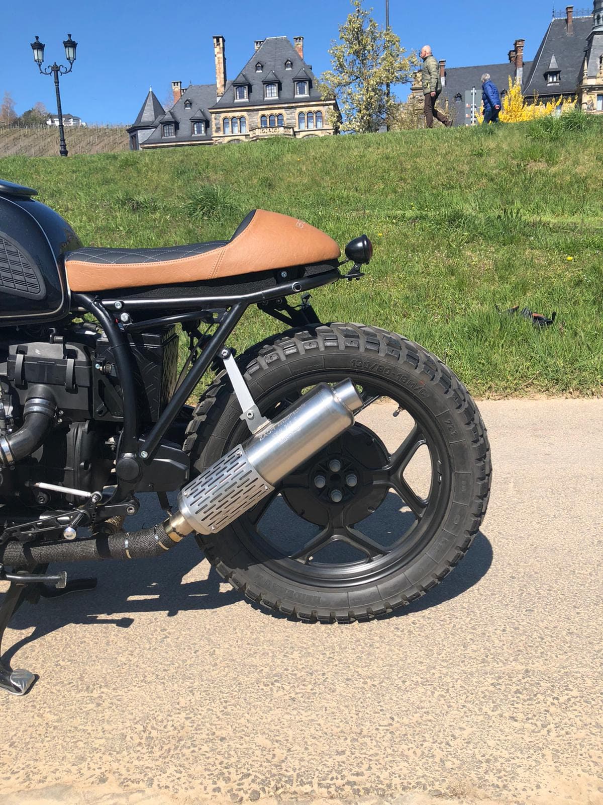 BMW Cafe Racer Hinterrad-Detail mit Sitzbank, Passanten im Hintergrund