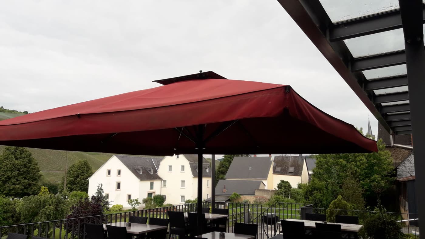 Roter Sonnenschirm auf Restaurantterrasse