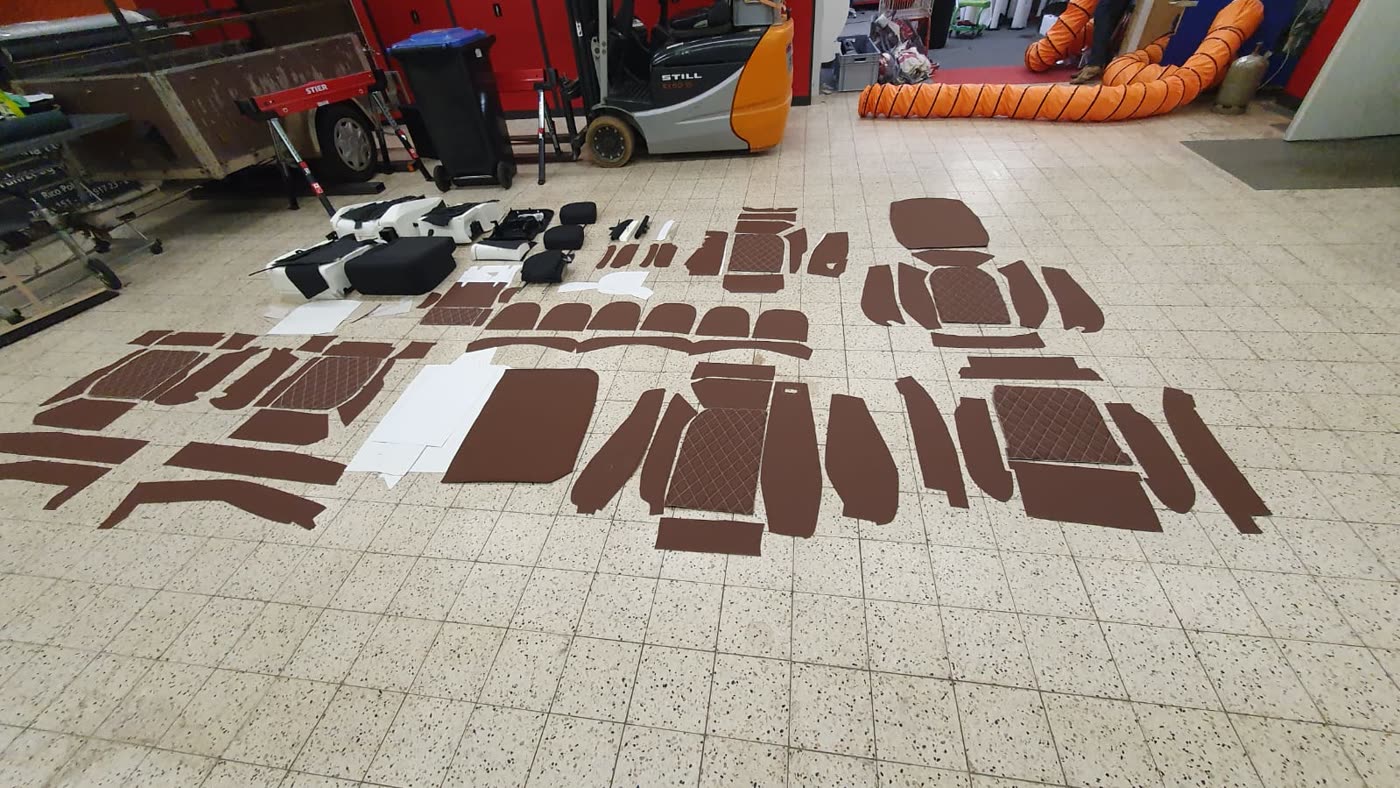 Zugeschnittene braune Lederteile für Sitzgarnitur am Boden