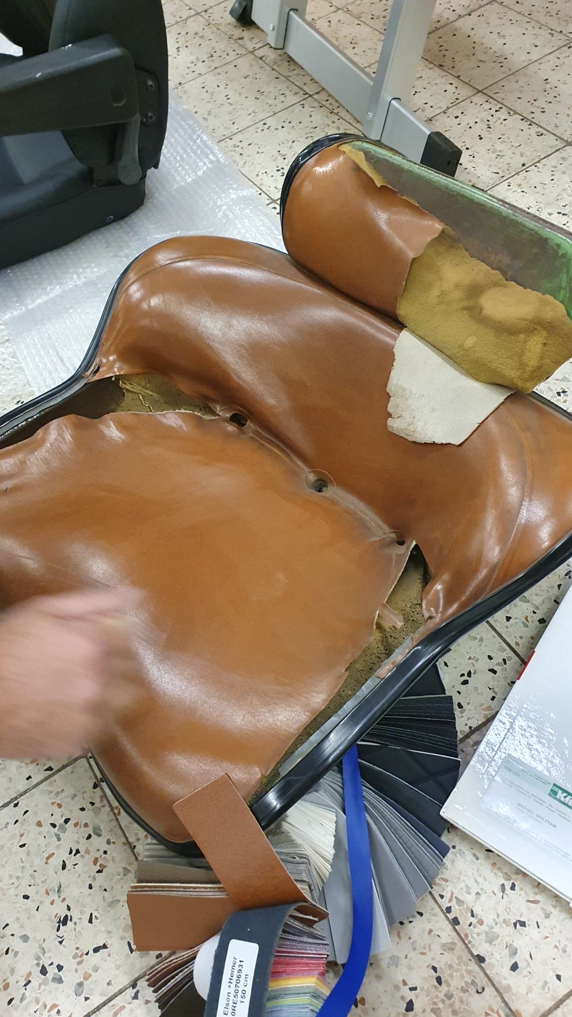 Beschädigter brauner Ledersitz, Reparatur im Gang